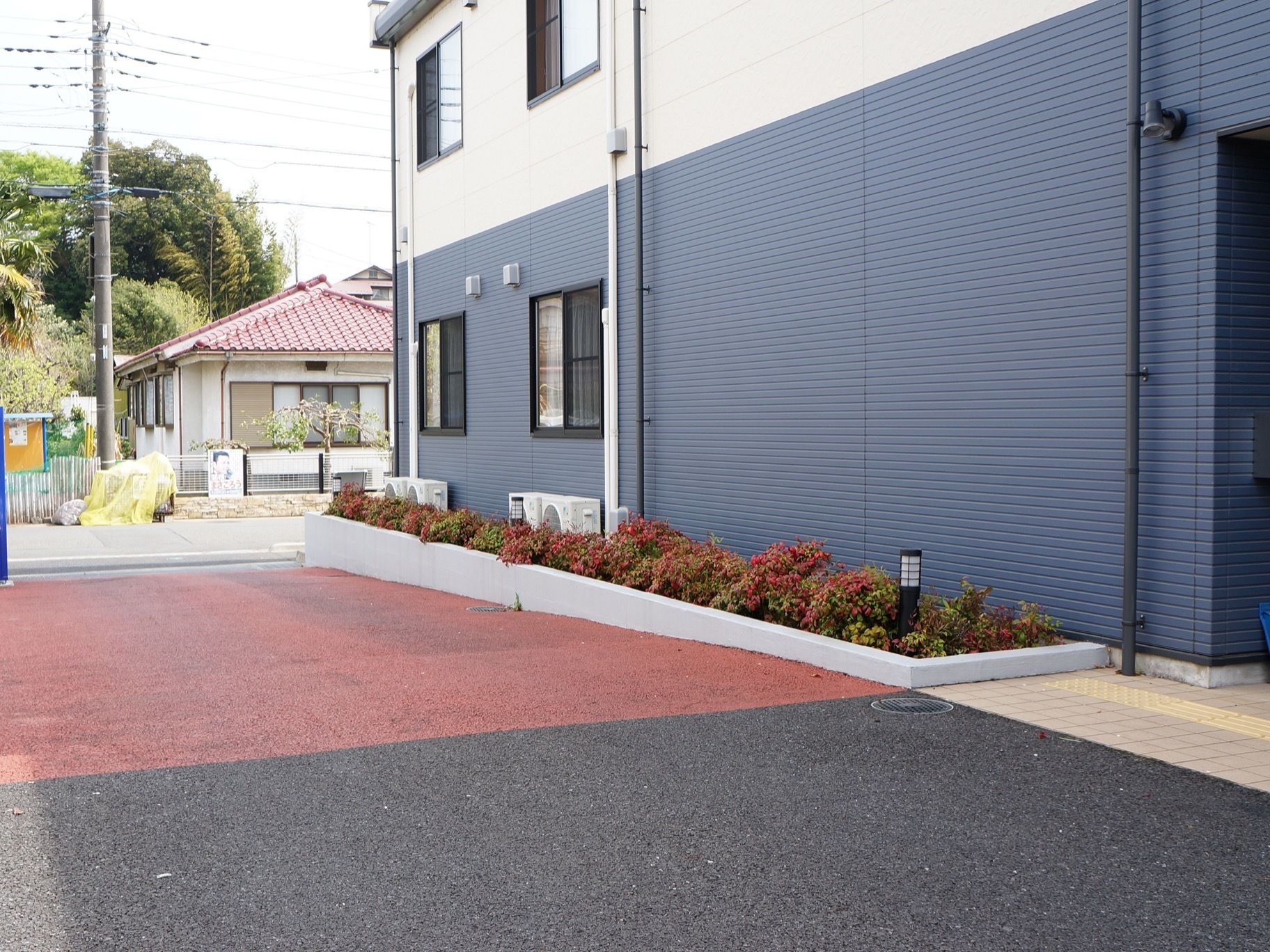 施設の駐車場にはスロープが設置されており、傾斜部分は赤い色で見分けやすくなっており転倒の防止になっている。