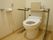 トイレには背当てや両脇の手すりが備わっている。壁には手すりがあり、緊急呼び出しブザーが設置されている。