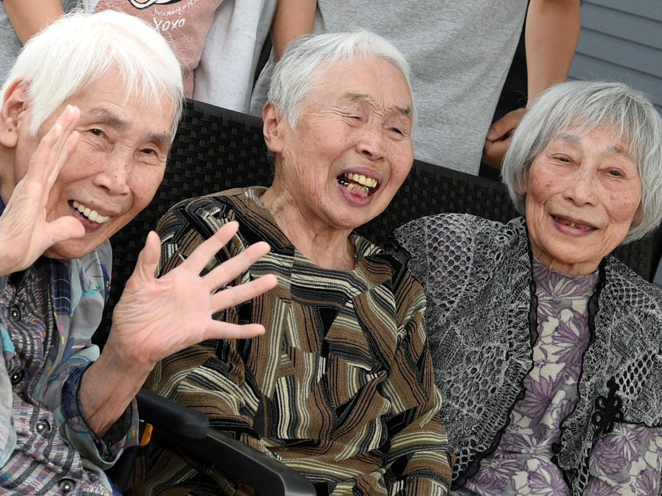 口を開けて満面の笑顔で写真に写る3人並んだシニア女性