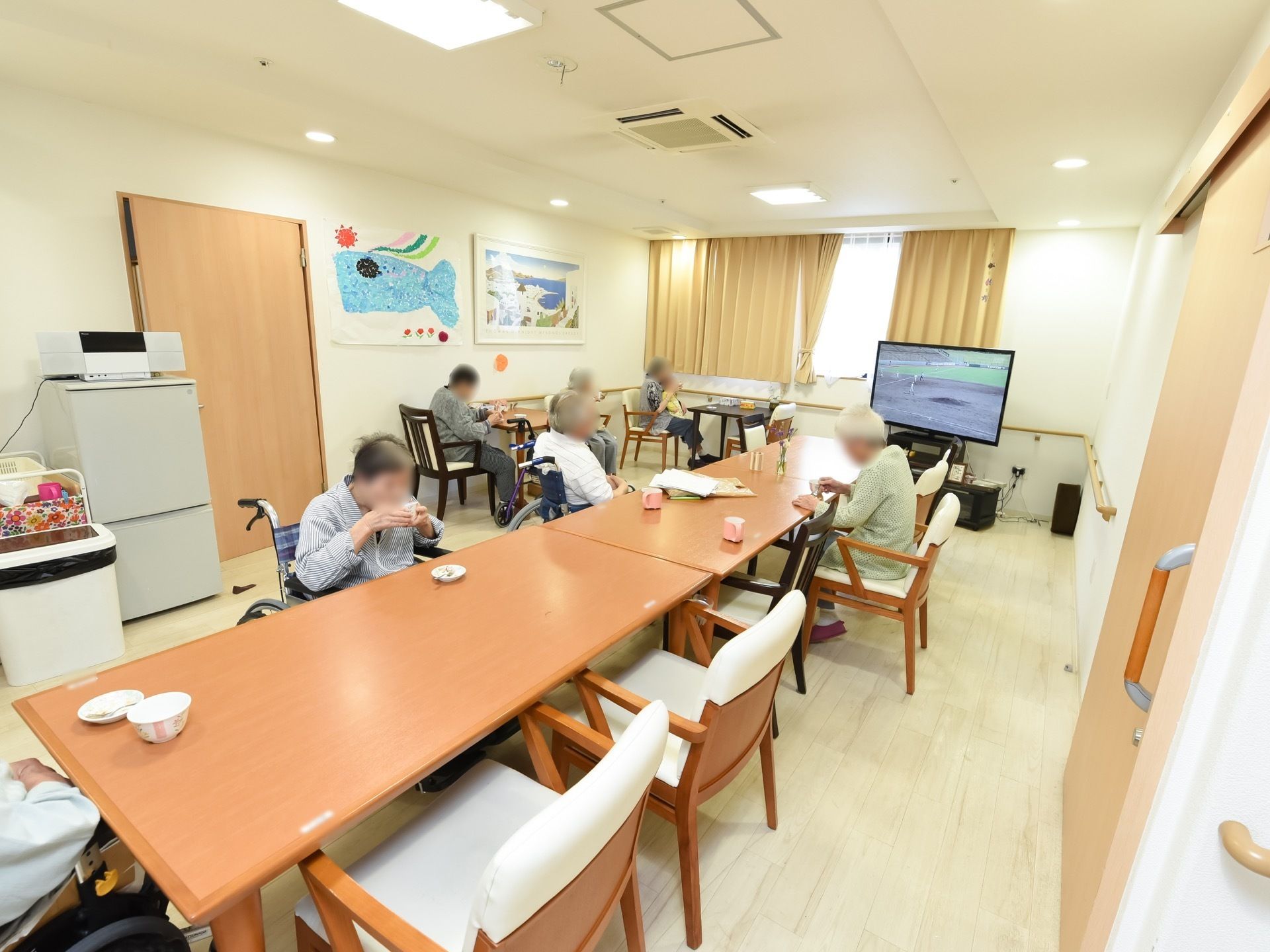 天井に埋め込み式のエアコンが完備され、大きなテレビや冷蔵庫が設置されている。また、壁には絵が２種類飾られている。