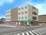 メイン道路に面した４階建ての施設である。玄関の前方の緑の側面に施設名を表示している。敷地内には駐車スペースを設けている。