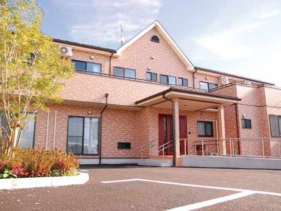大きな民家のような外観である。入口までの道のりには手すりが設置されている。駐車場が十分に用意されている。