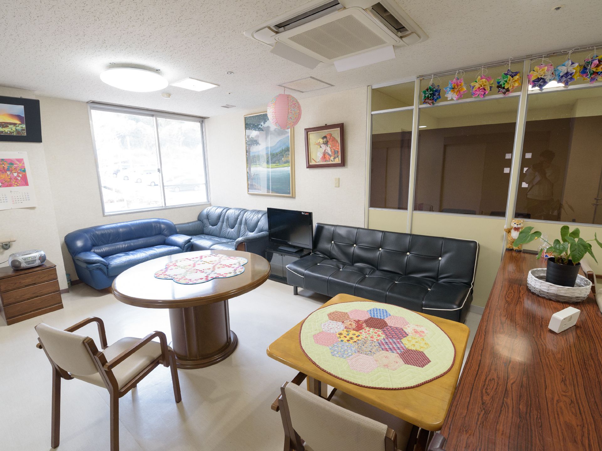 談話室にはテーブルとソファ、テレビがある。入居者様同士でコミュニケーションが楽しめる。壁には絵画がある。