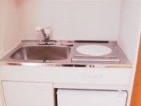 居室に備え付けられたミニキッチンである。シンクの横にIHコンロが１口設置されており、下には収納スペースがある。