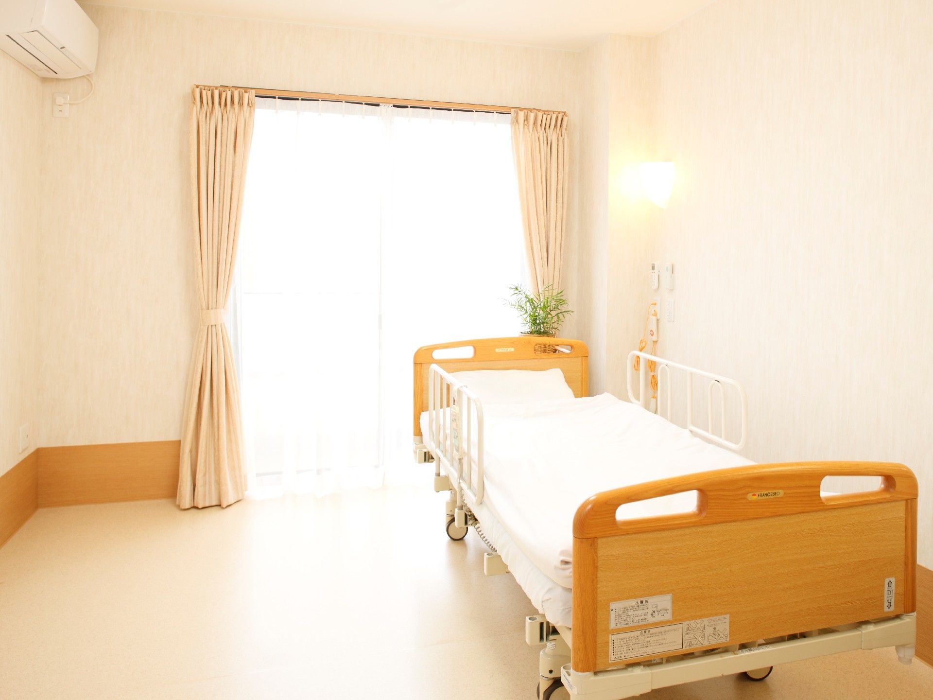 突き当りに窓があり、壁際に電動式の低床型ベッドがある。壁には非常用ブザーが付いている。反対側の壁にはエアコンが設置してある。