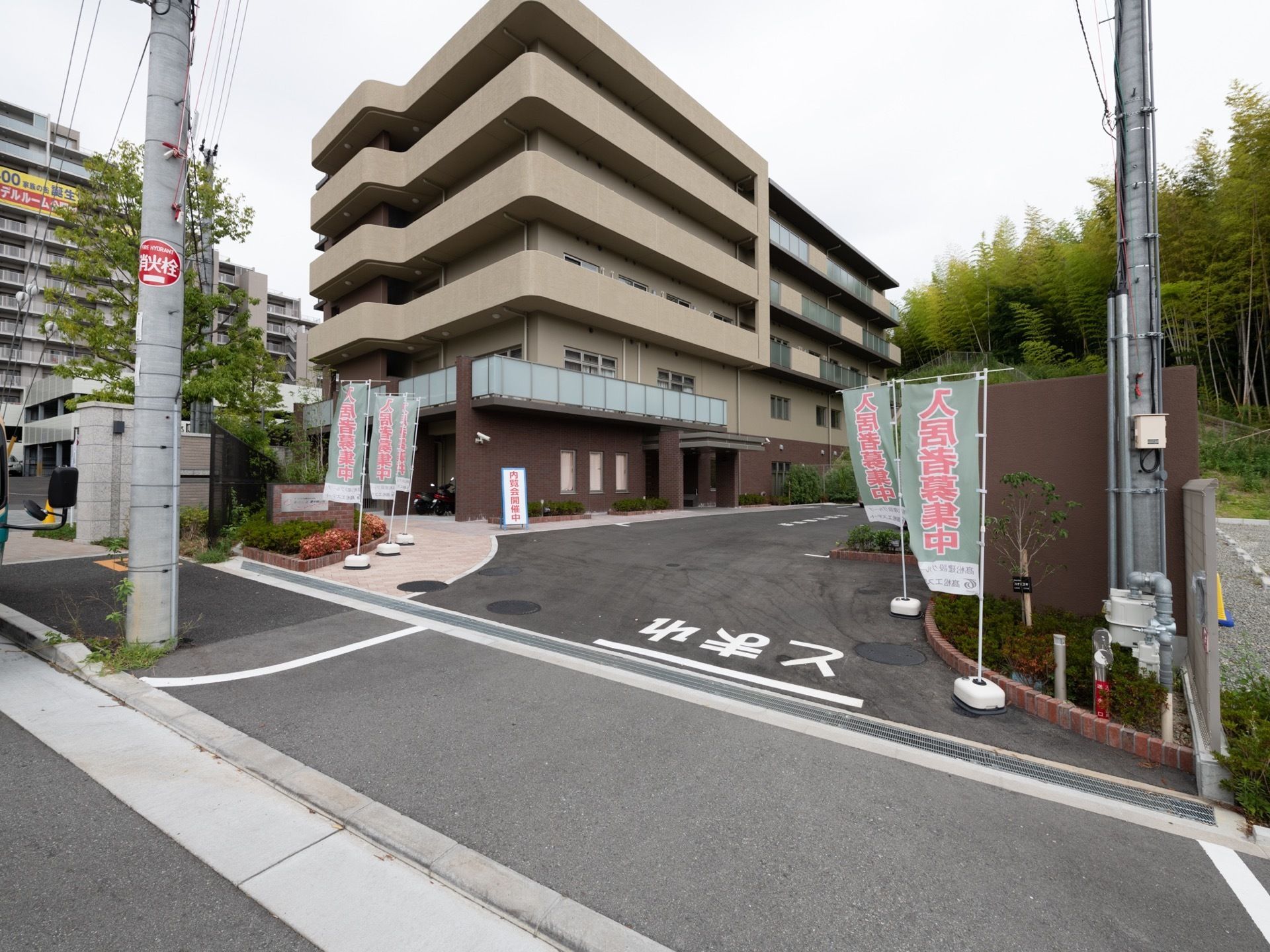周囲のマンションや自然の木々の色合いと調和した佇まいの施設である。建物の2階以上の部屋の外周には、ベランダが設けられている。