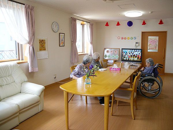 明るいリビングルームでテレビを見ながらくつろがれる女性3人