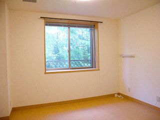 ナチュラル色の窓枠とフローリングが、窓から見える緑とマッチする居室