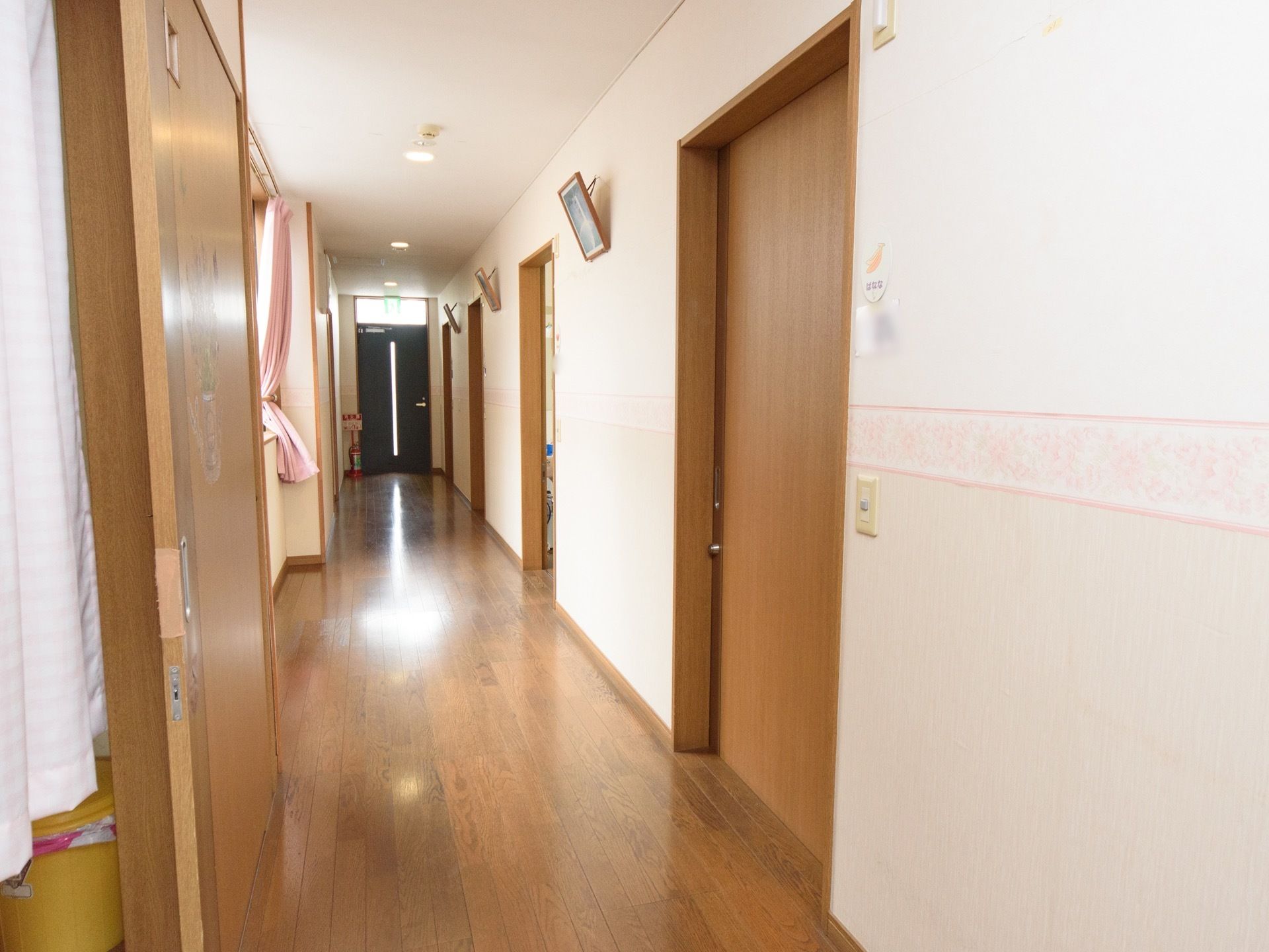 フローリングの広い廊下が続いている。採光窓から入ってくる外光と照明で、明るく見通しが良くなっている。