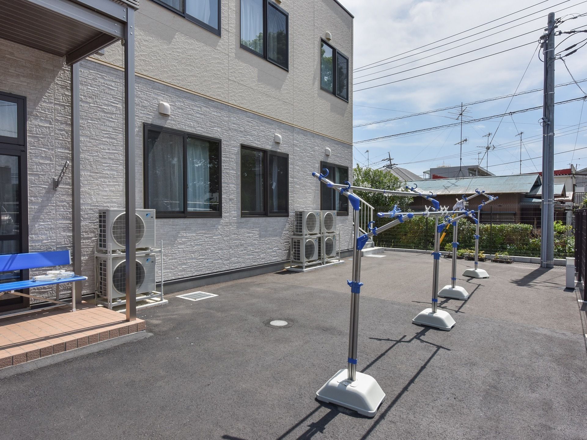 外壁はブラウンが基調になっており建物の周りには広いスペースがある。物干し台があり、多くの洗濯物を乾かすことができる。