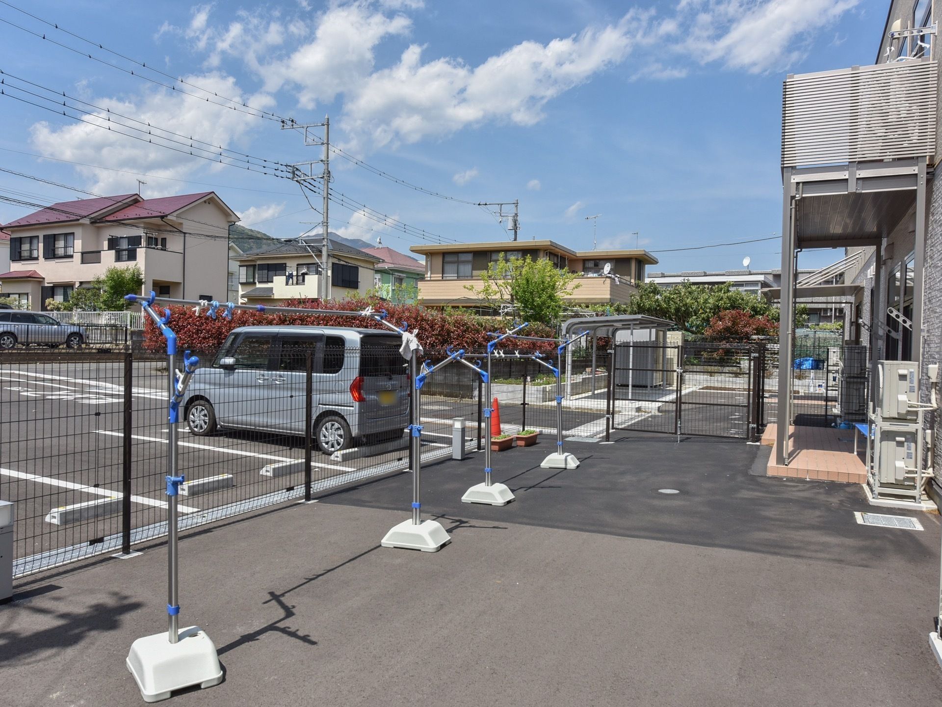 敷地は広く、建物の脇には物干し台が２つ置かれている。その隣には広々とした駐車場を備えており、多くの車を停めることができる。