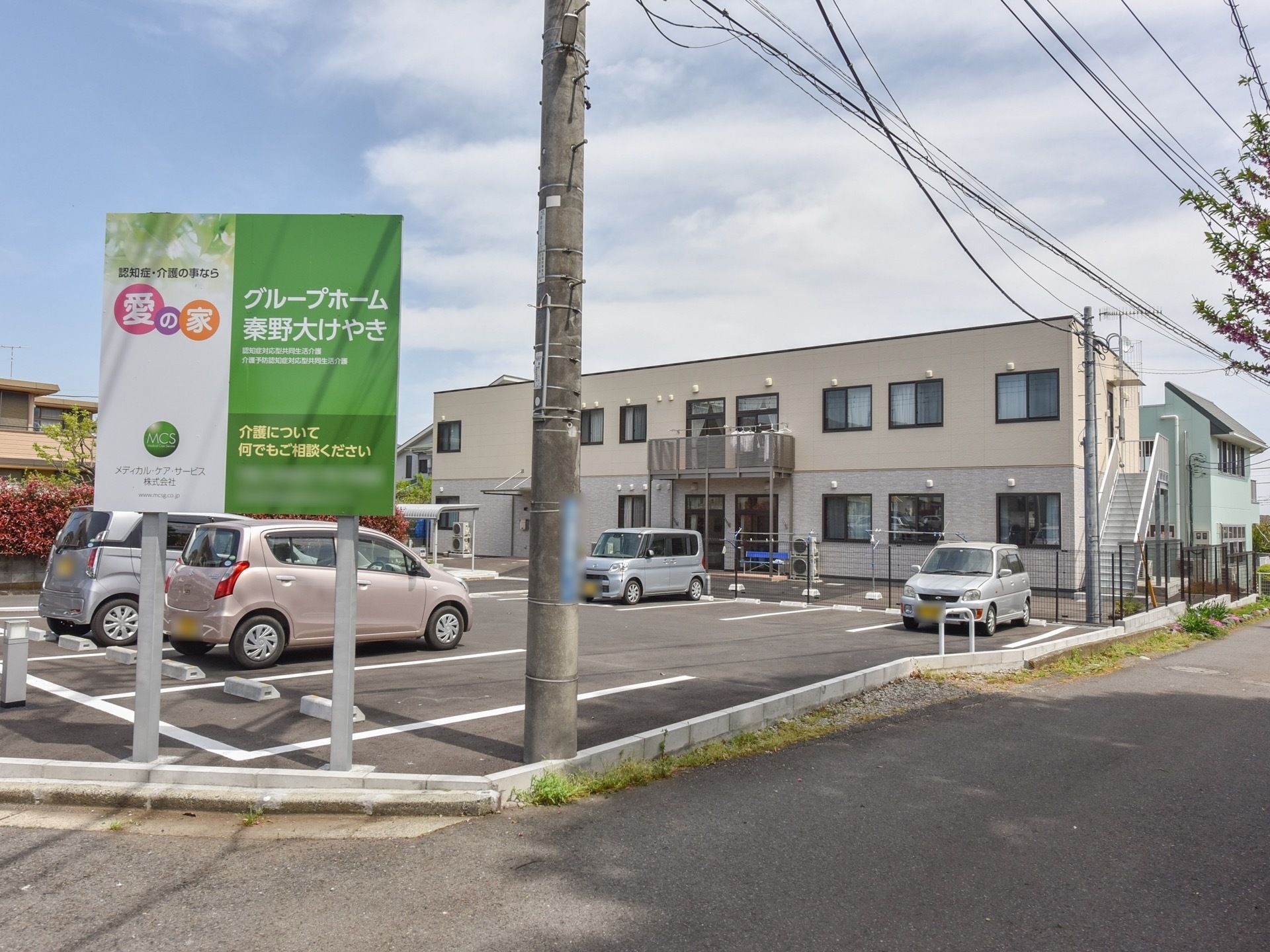 敷地は広々としており、外壁がベージュ色の２階建ての建物である。外階段が設置されており、いざという時に避難をする場合も安心である。