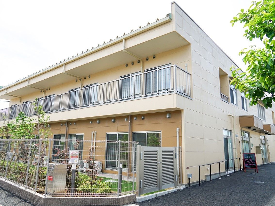 ２階建ての建物の２階にはベランダが、１階部分には季節の花が植えられた庭がある