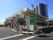 ２階建ての明るいオレンジ色の建物である。２階のベランダから外に降りる階段が繋がっており、看板が建てられている。
