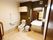 施設共用のトイレは、車椅子対応の広い部屋の構造をしている。便座には背もたれとひじ掛けが一体になったパーツが追加されている。