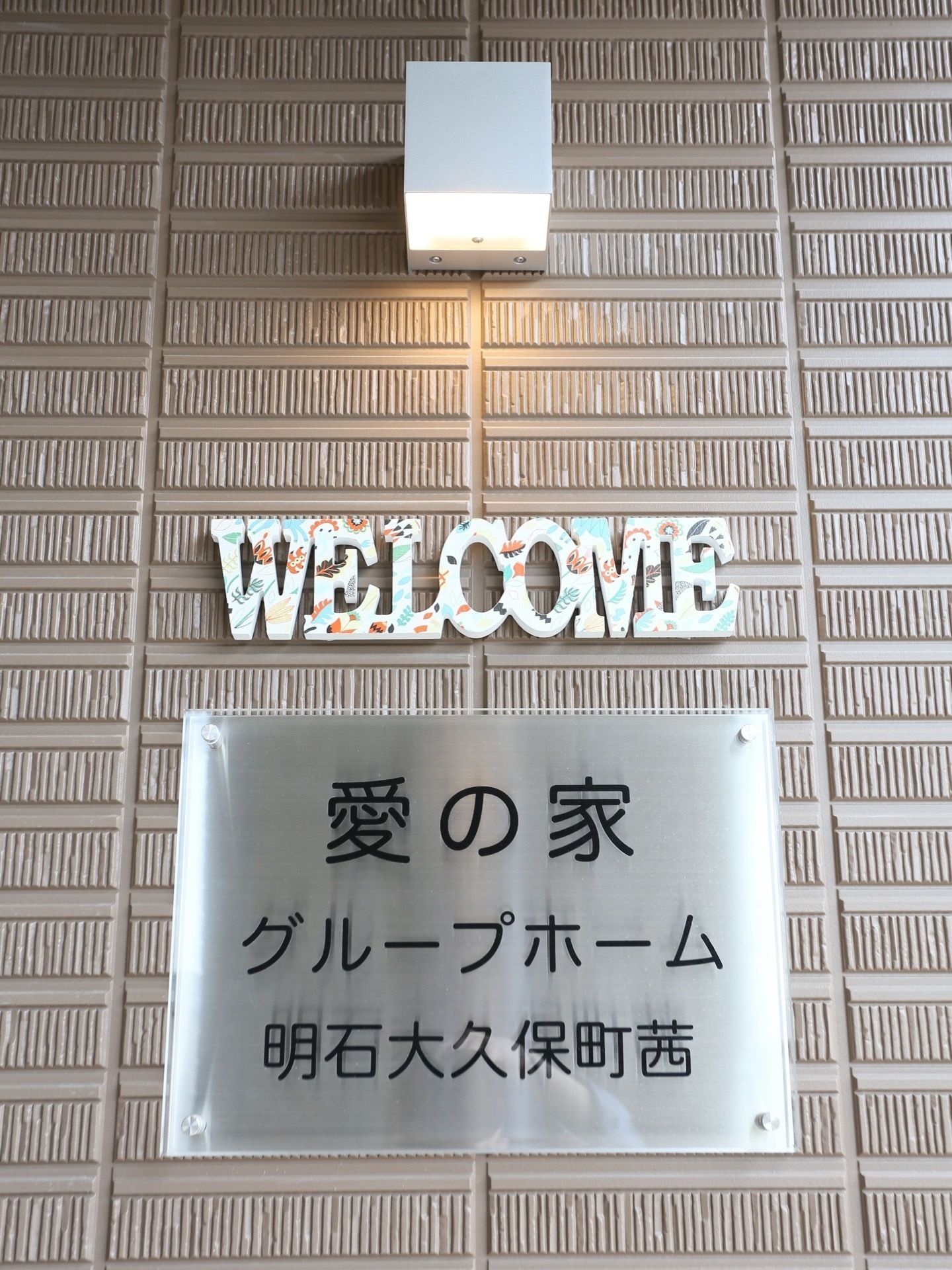 ホームの名称と住所が表記された、壁面サインプレート