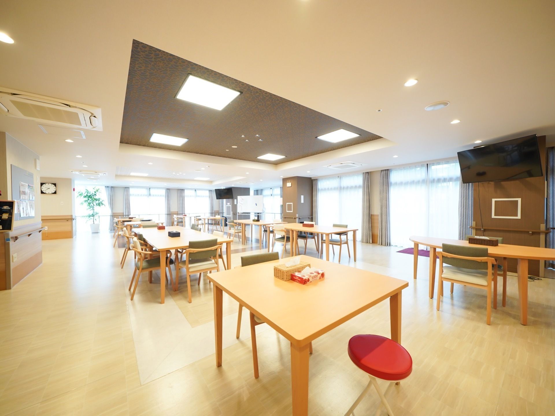 女性スタッフと入居者が笑顔で談笑する白い壁のあるスペース