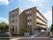 マンションタイプの施設の建物は4階建てで、ブラウンを基調とした外観である。花壇があり樹木が植えられている。