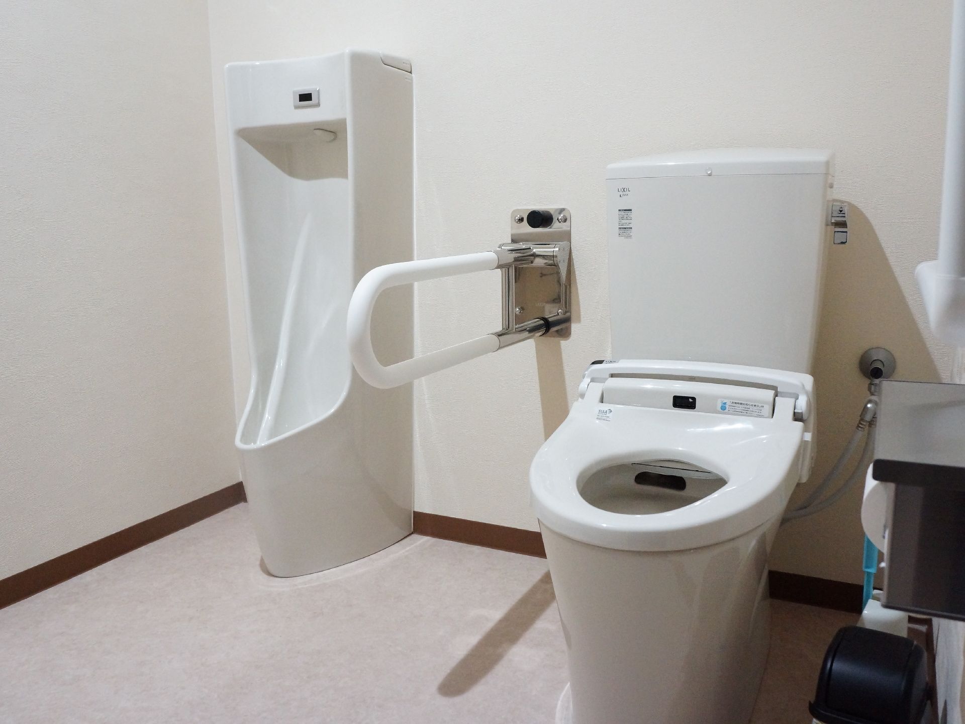 トイレには、男性用小便器と、便座が1セットで設置されている。2つの便器の間には手すりも付けられている。