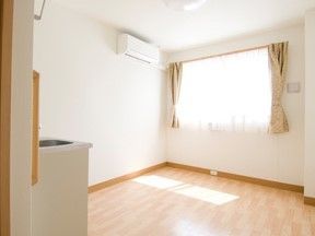 白い内装でフローリング、右正面に窓があり、その左上にエアコンのある居室