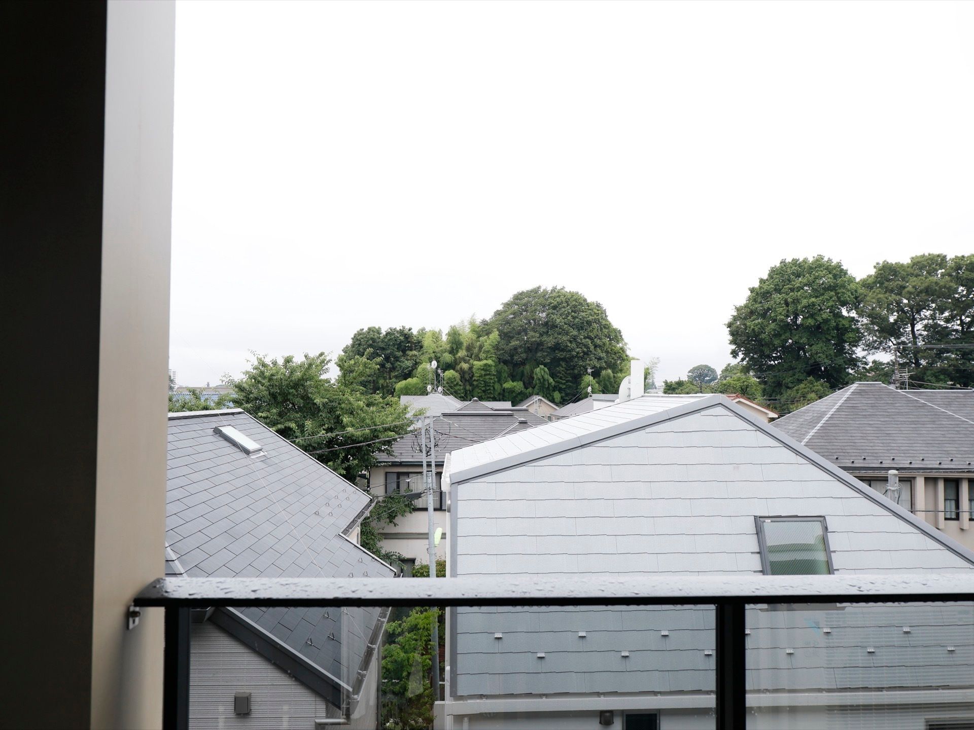 ベランダからは、民家や木々などを見ることができる。周囲に高い建物がない落ち着いた環境で生活することができる。