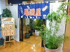 居酒屋と書いた暖簾がかかった、お勧めのメニューの看板のある入口