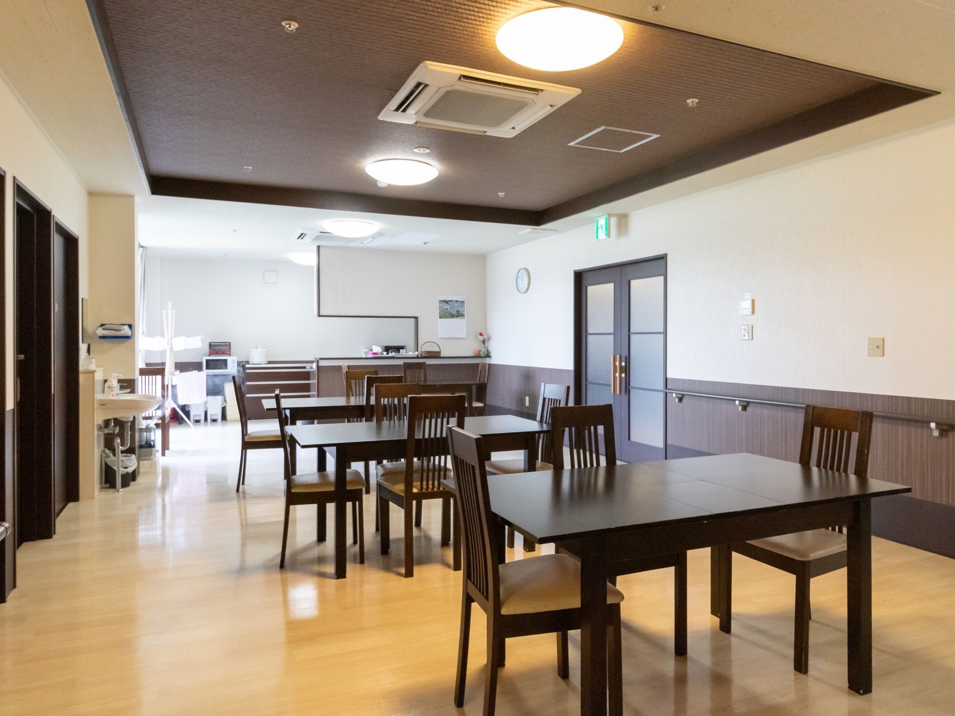 こげ茶色で統一された家具があり、落ち着いた雰囲気の空間である。天井には、埋め込み式のエアコンが設置されている。