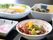 黒いお盆の上に並べられた、1人分の食事の一部である。さまざまな器に盛られた色とりどりの主菜や副菜がある。