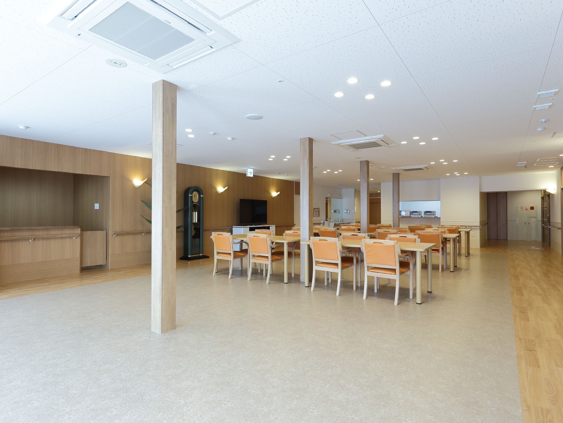 広いホールの中央に細い柱が数本立ち並び、柱を挟むようにしてテーブルと椅子が設置されている。半分ほどの空間は広く確保されていて開放的な印象。