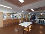 車椅子の人も利用しやすい広さとなっている。段差がない床であり、安全な歩行ができる。テーブル、椅子が設置されている。