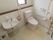 広々としたトイレである。手すりが複数配置されていて、安全性が高い。室内は全体的に明るく、清潔感がある。