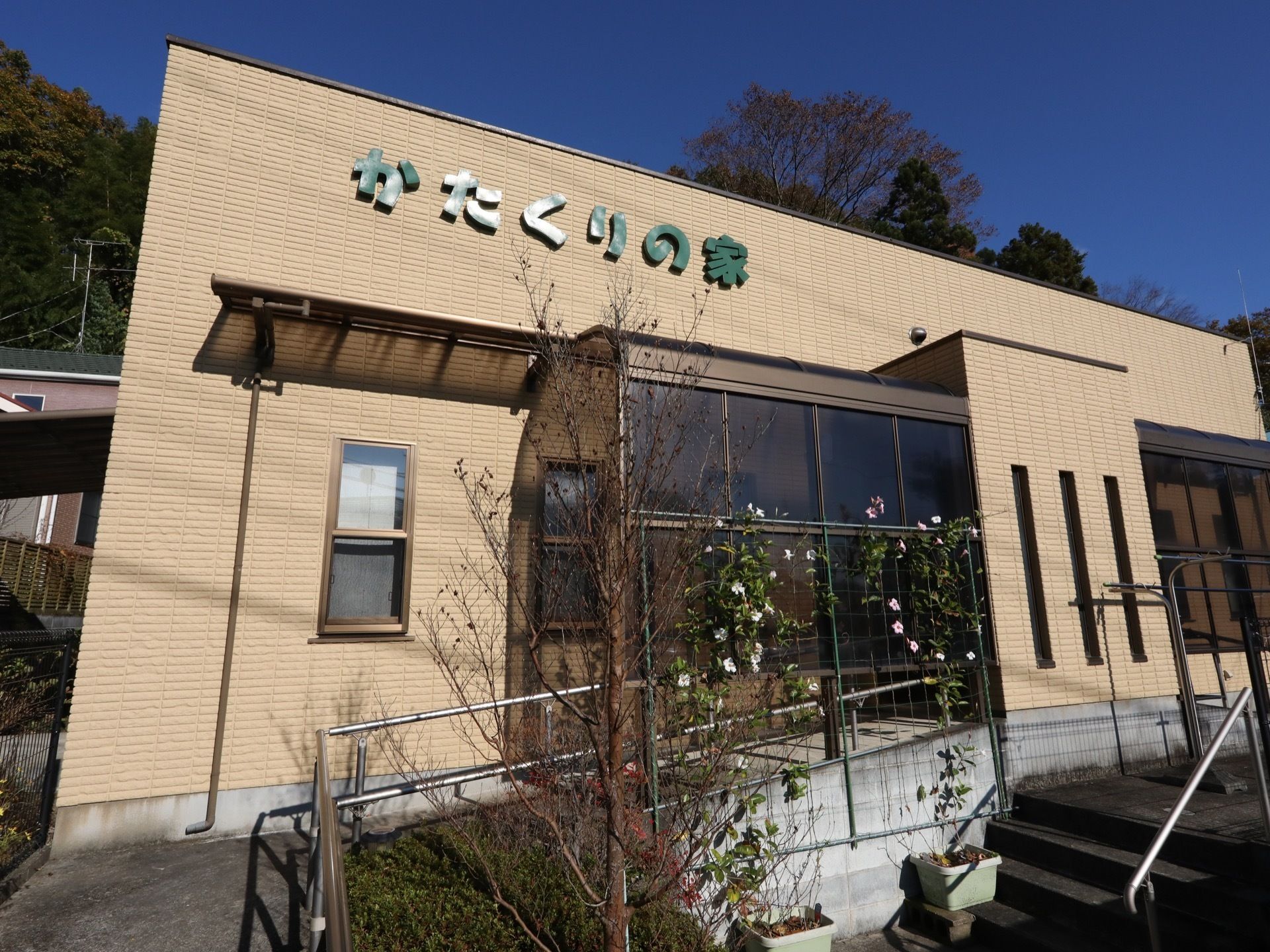 レンガ造り風の茶色の建物である。入口の近くでは庭木や花が育てられており、親しみやすさを演出している。