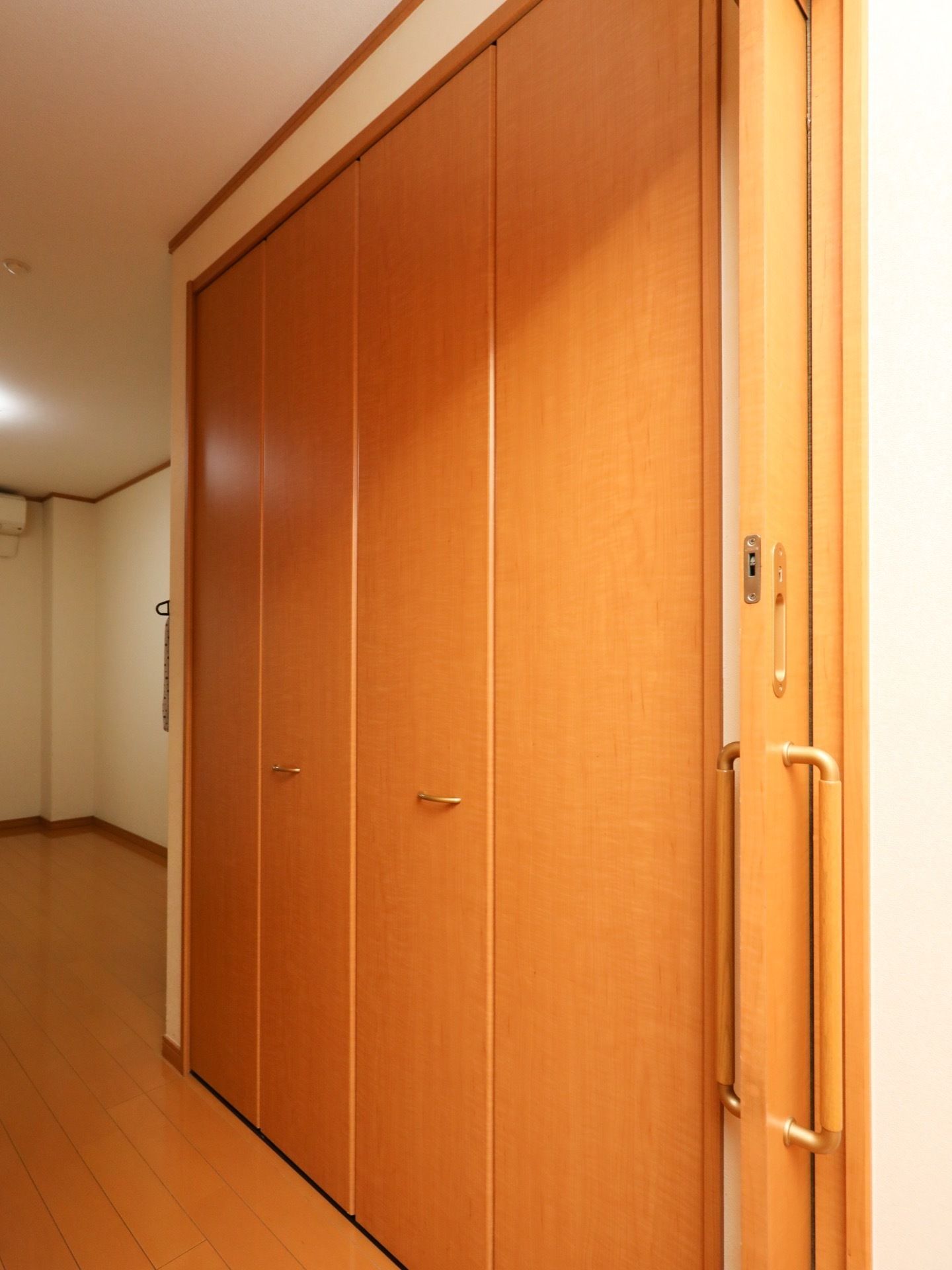 クローゼットの扉は4面の折れ戸タイプになっている。板間の床と同じ優し気な木目調が、部屋の景観にしっくり馴染む。