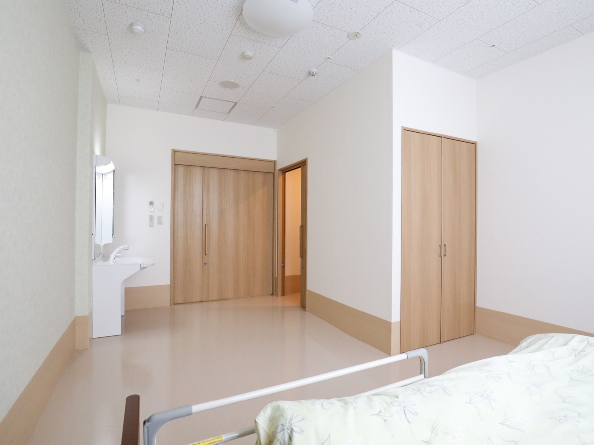 床がフローリングの1Rの洋室である。室内には、洗面台と収納力のある両開きのクローゼットが設置されている。