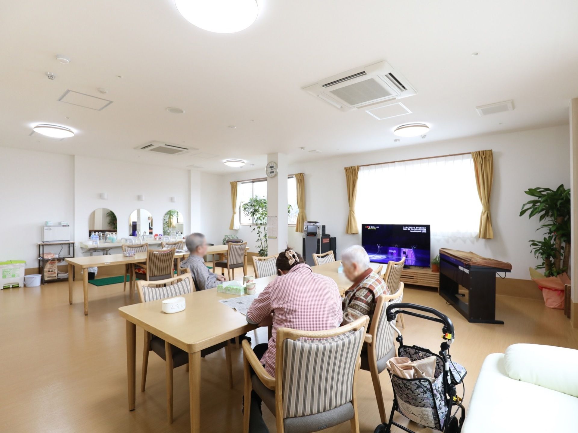 テレビを観たり、新聞を読んだり入居者様それぞれの時間を楽しんでいる。奥には、手洗い場が設置されている。