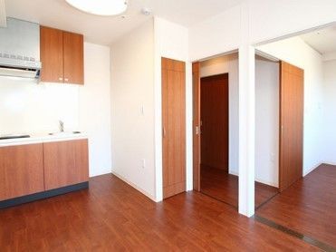 部屋は広々とした個室で、キッチンが備わっている。濃い茶色の木目調で統一され、温かみのある空間となっている。