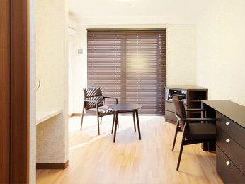 居室は家具付きの部屋。引き出し付きのデスクと椅子、テーブルやドレッサーなどが備え付けられ、すぐ生活できるようになっている。