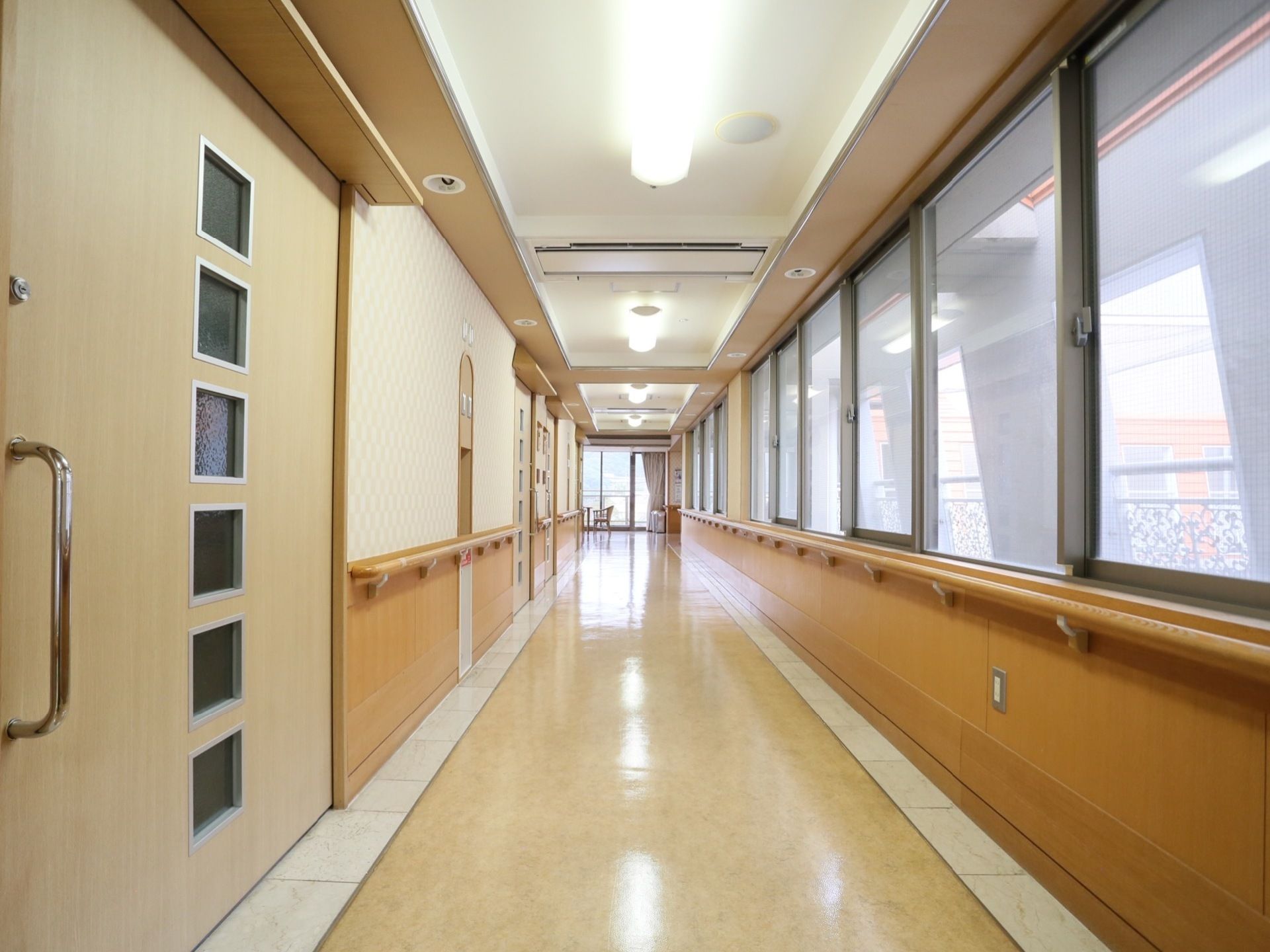個室の扉は引き戸になっている。日当たりが良い廊下には両側に手すりが備わっている。通路の幅も広々しており、歩行もスムーズに行える。