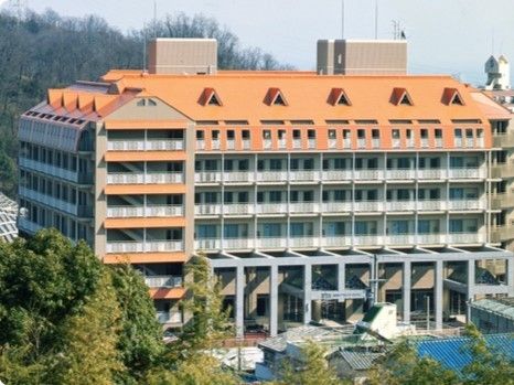 グレーの外壁にライトブラウンの切り替えが入った外壁、オレンジの切妻屋根の建物