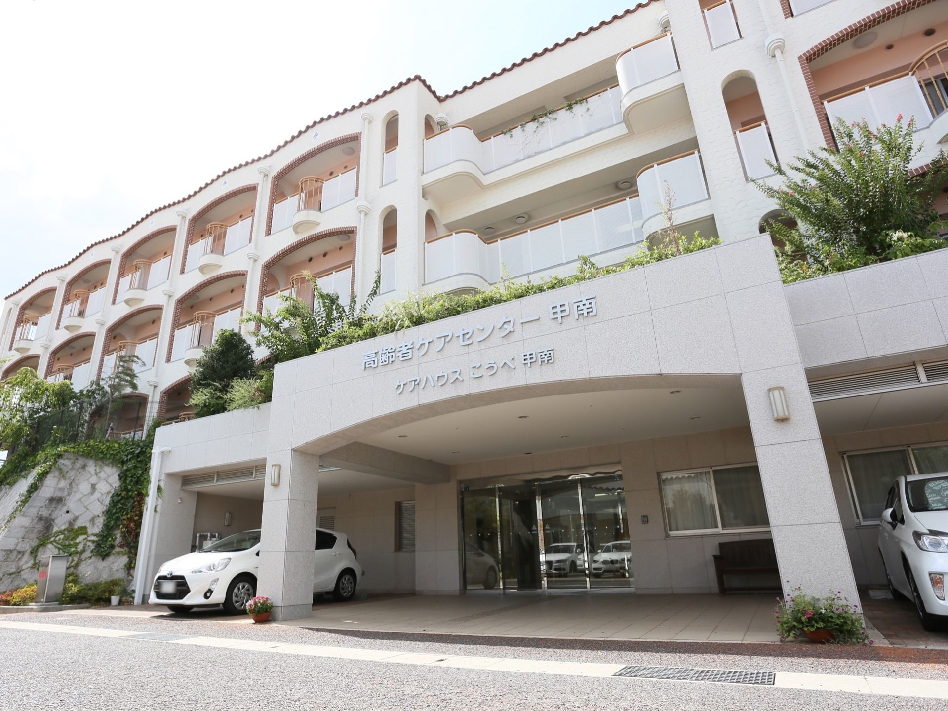 施設は4階建てのマンション風の建物になっている。施設入り口には車が2台止まっており、入り口は自動扉になっている。