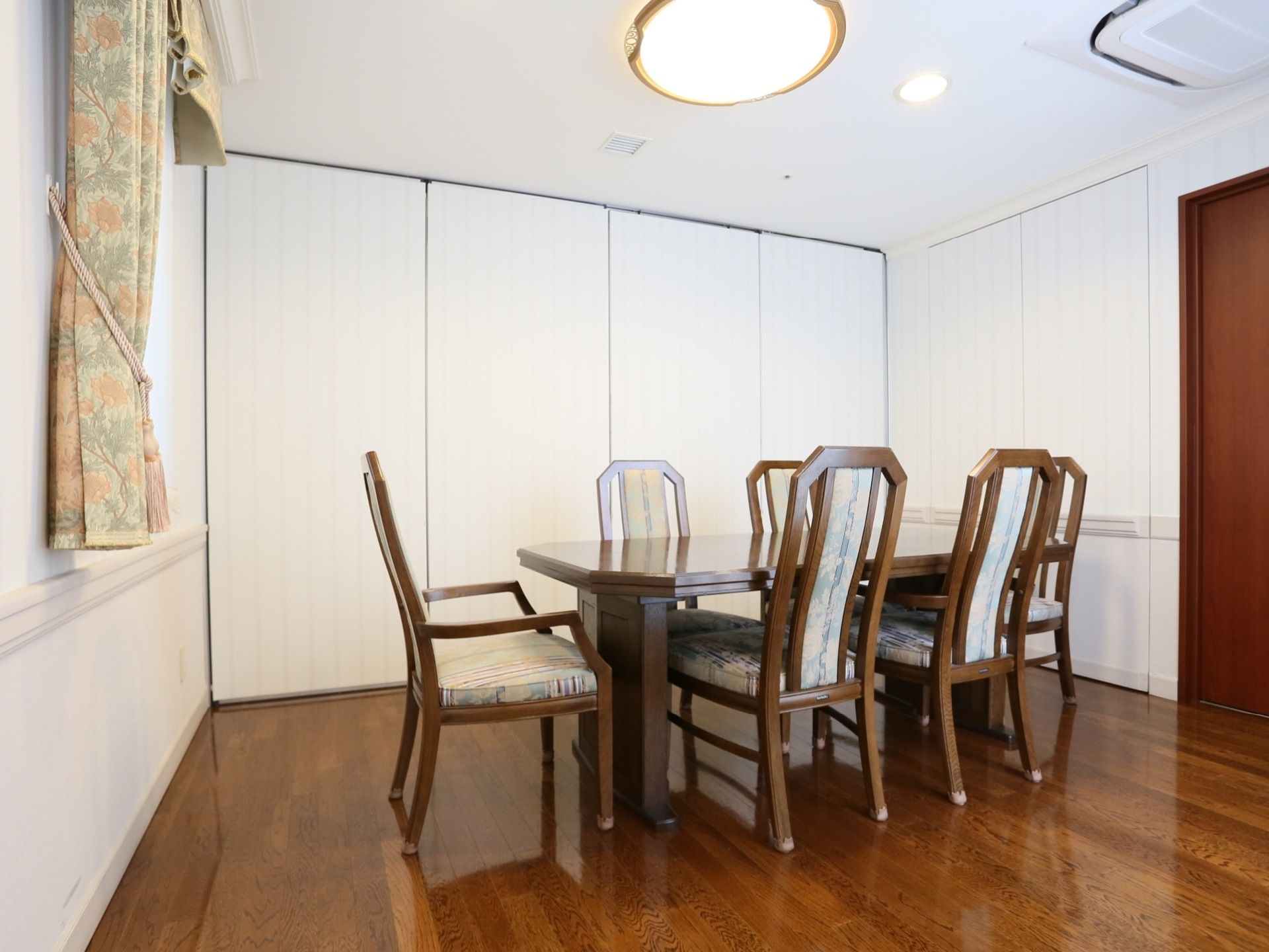 床は落ち着いた茶色の木目調タイプである。アンティーク調のテーブルと椅子が備えつけられている。空調設備も完備。