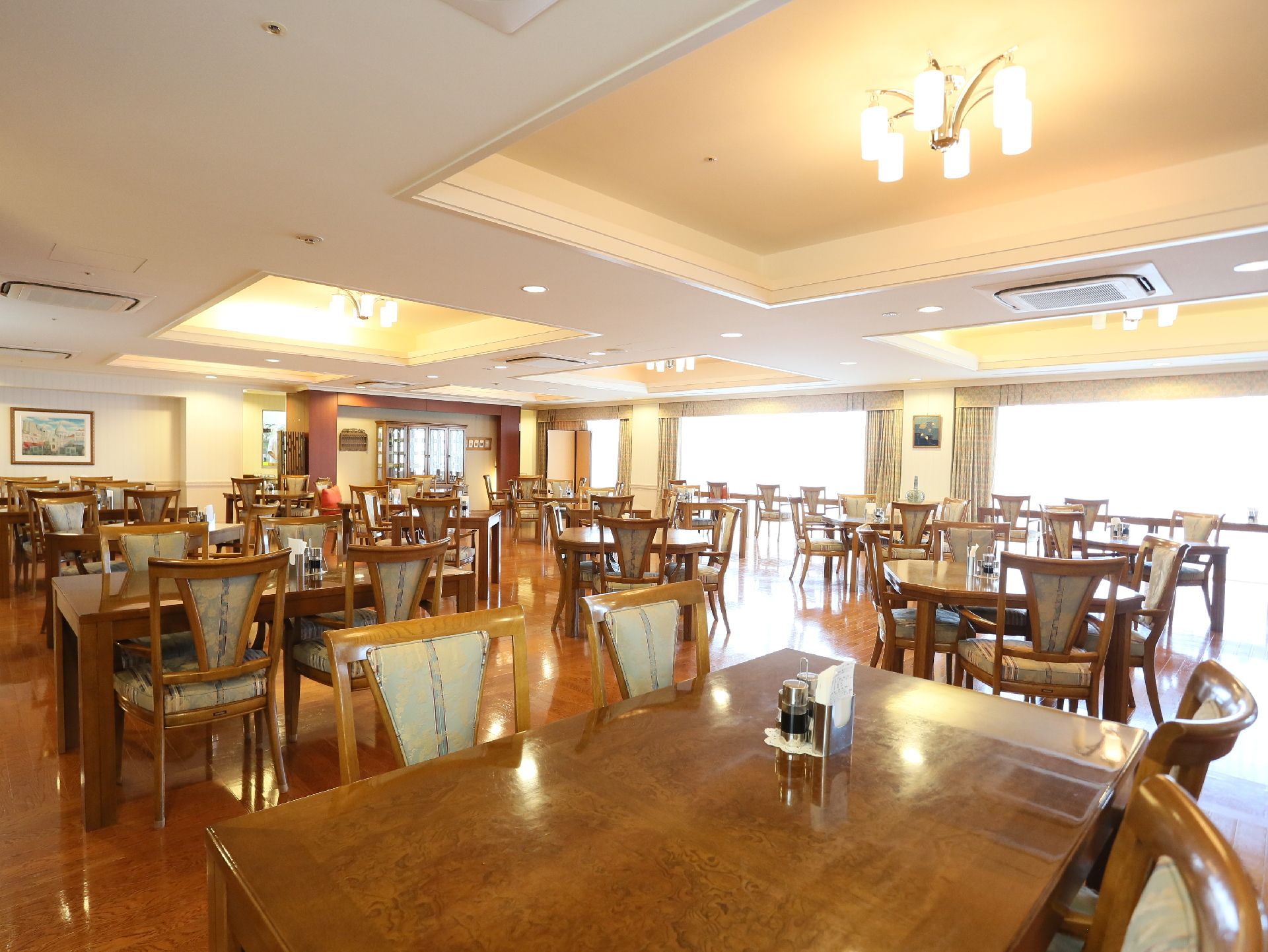 広いリビングでは、いくつものテーブルが並べられ、入居者様の食事のほか、交流を深める場所としても利用できる。