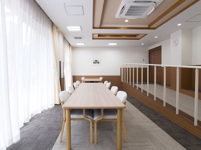 手すりや椅子に白色を取り入れた、爽やかな印象のラウンジである。大きな窓に面しており、自然光と風を感じながら過ごせる。