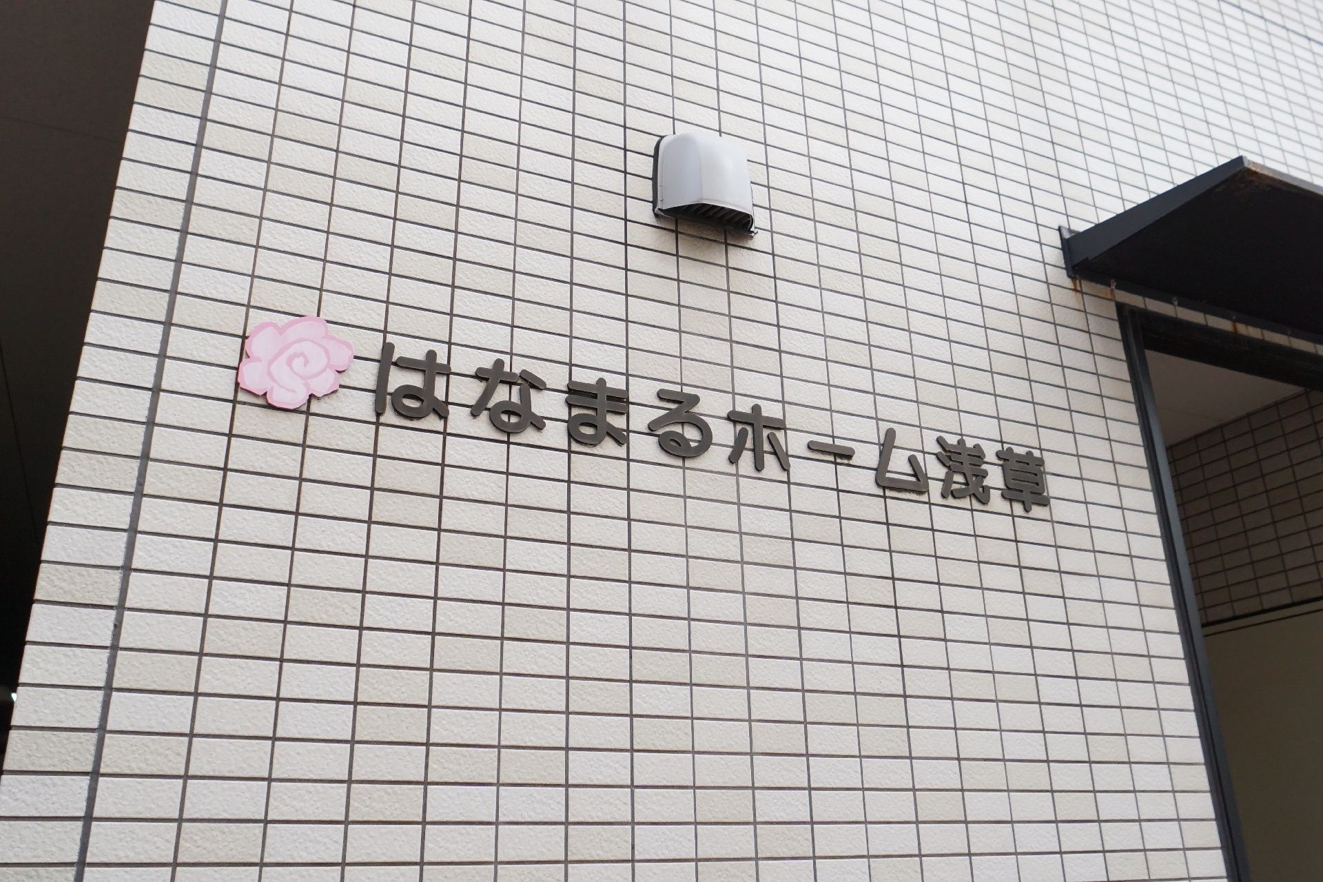 車椅子に座っている高齢女性に手を差し伸べる女性ヘルパー