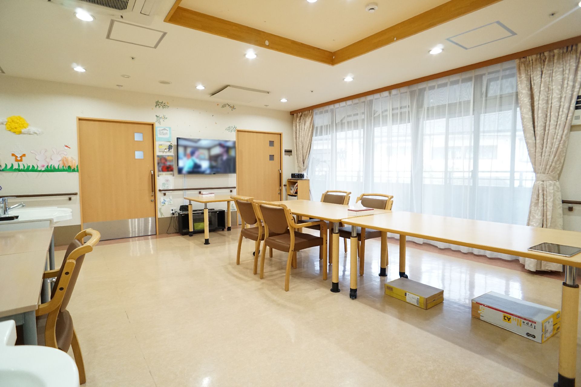 木目調のテーブルと椅子が設置された共有スペース