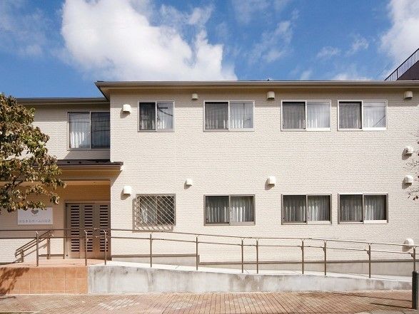 施設は２階建ての建物である。手すりが備わったスロープと階段がエントランスに設けられている。玄関扉は大きく開閉できる引き戸になっている。