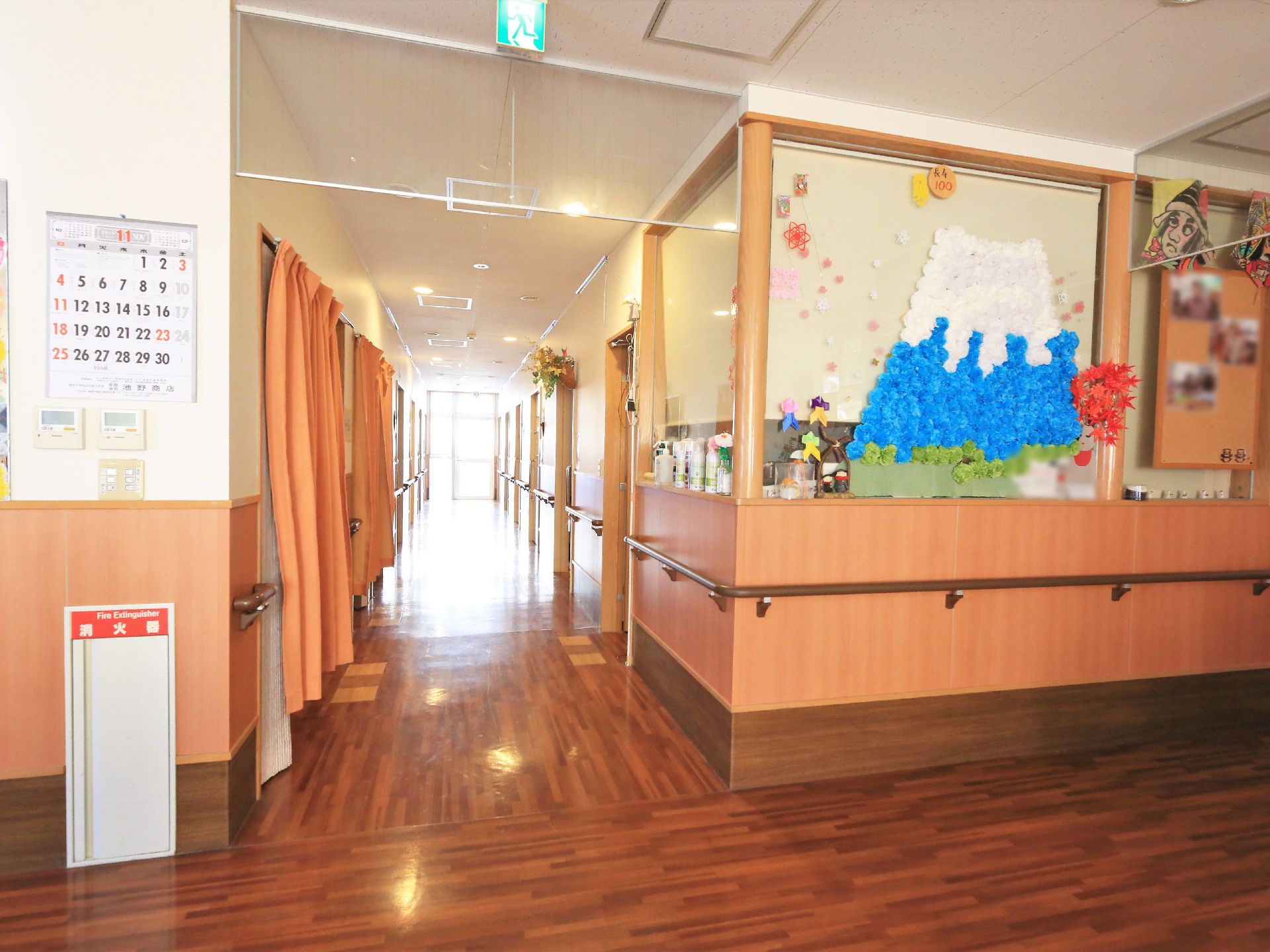 幅の広い廊下になっている。両側には手すりがしっかりと設置されている。白色と茶色を基調としており、落ち着いた印象である。