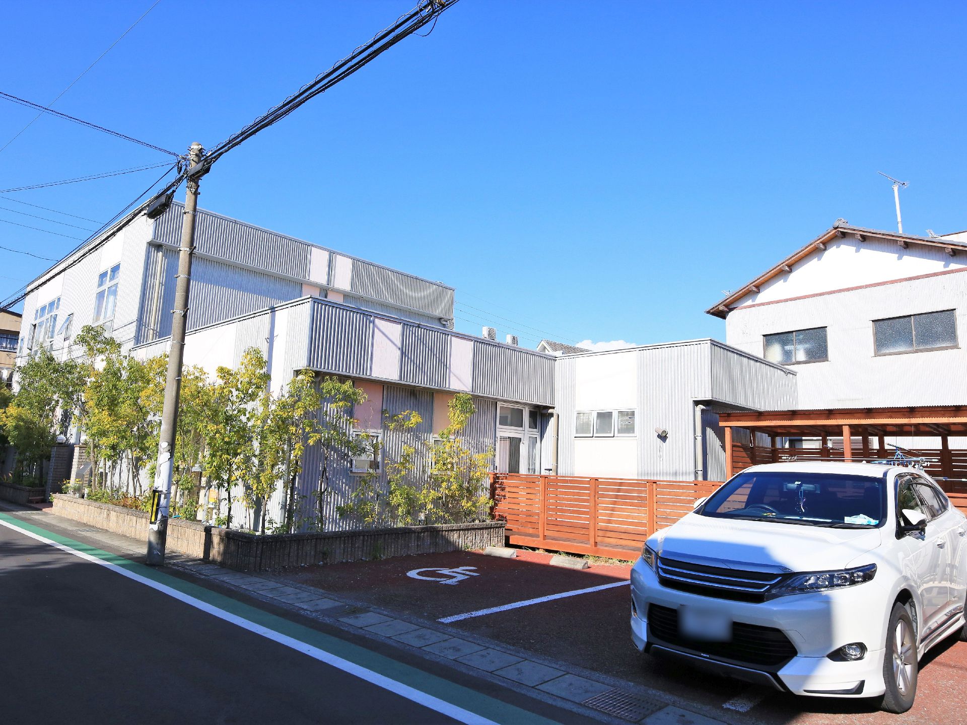 シルバー色を基調とした外壁の、一部２階建ての施設である。道路に面した部分には背の高い木が何本も植えられている。