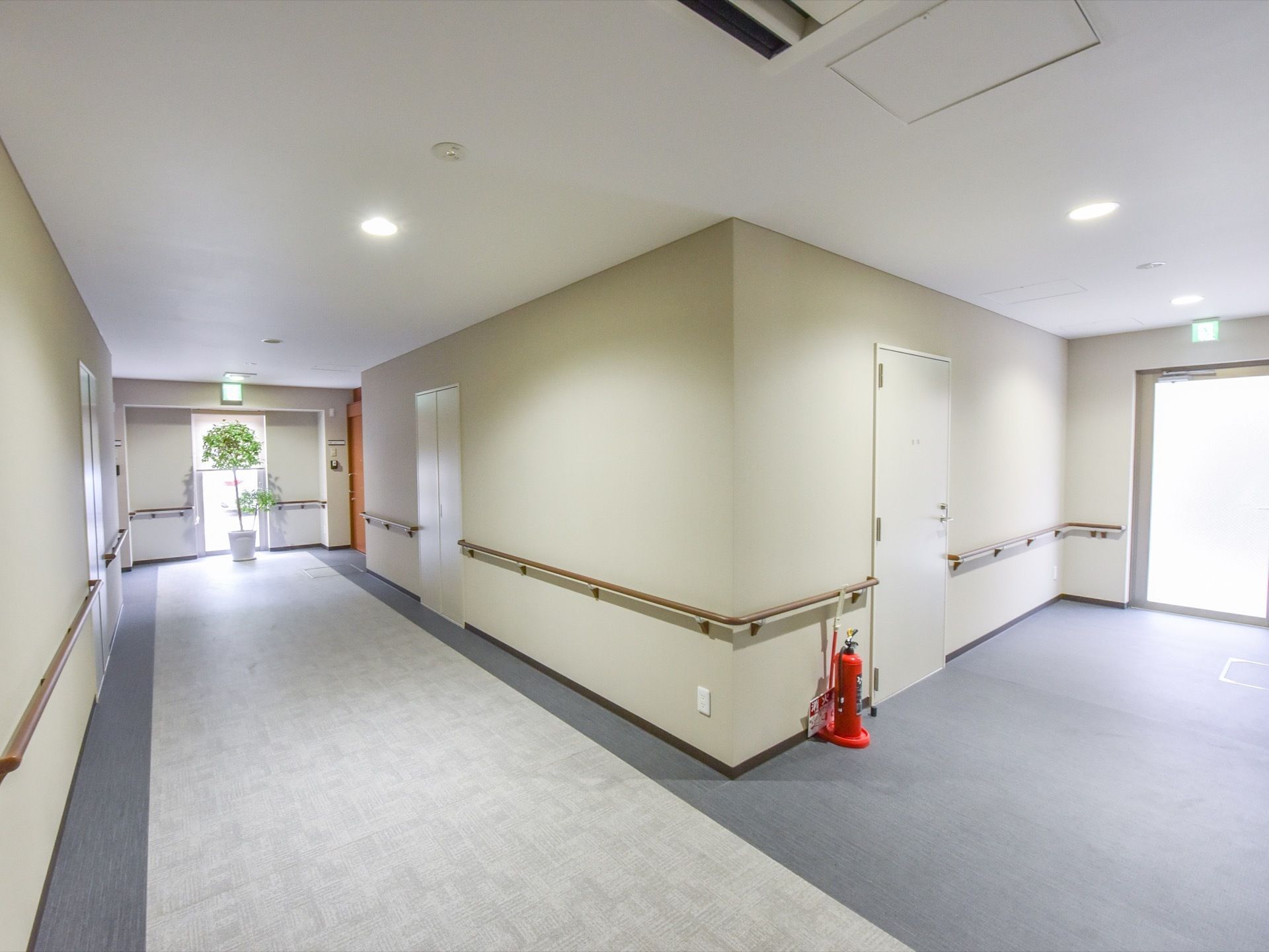 通路の壁は白く、明るく清潔感のある印象を受ける。非常口は複数あり、扉も大きい。通路にも空調が設置されている。