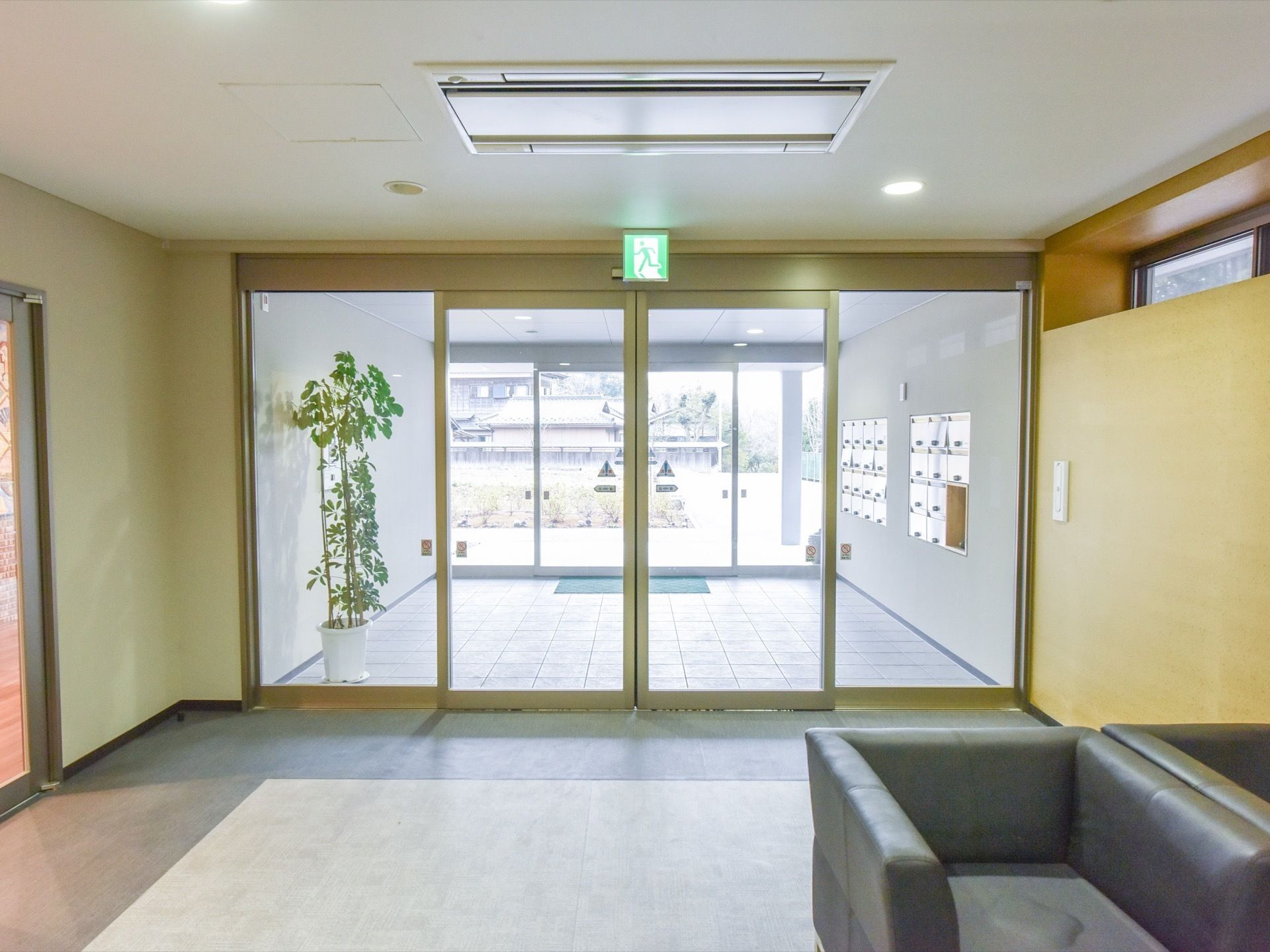 自動ドアは２重構造になっている。玄関は広く足元に段差がない。壁には郵便受けが設置されている。ソファーもある。